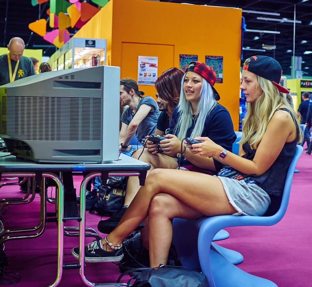 Understanding Game Updates Young players holding controllers and playing a console game at a gaming event
